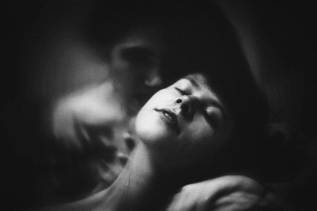Portrait-format photo of two people laughing together on a bed, soft warm indoor lighting, casual comfortable clothing, playful and joyful mood, medium close-up shot, natural skin tones - Photo by Vitaliy Shevchenko on Unsplash