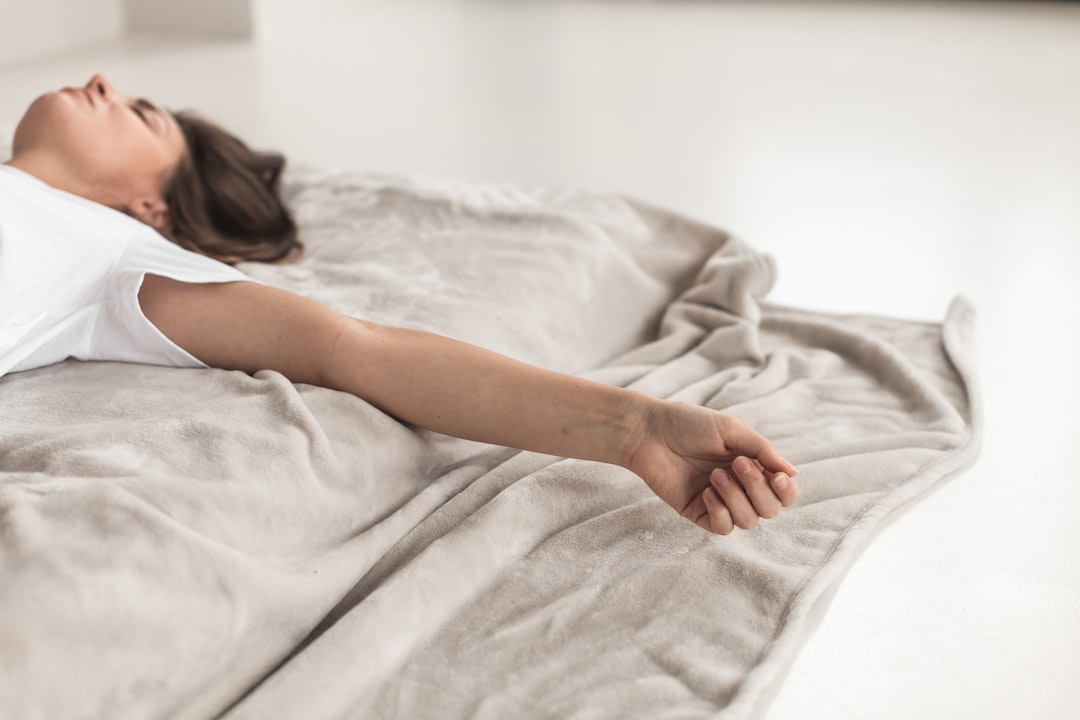 Close-up of a person's hand resting on a soft linen surface, calm